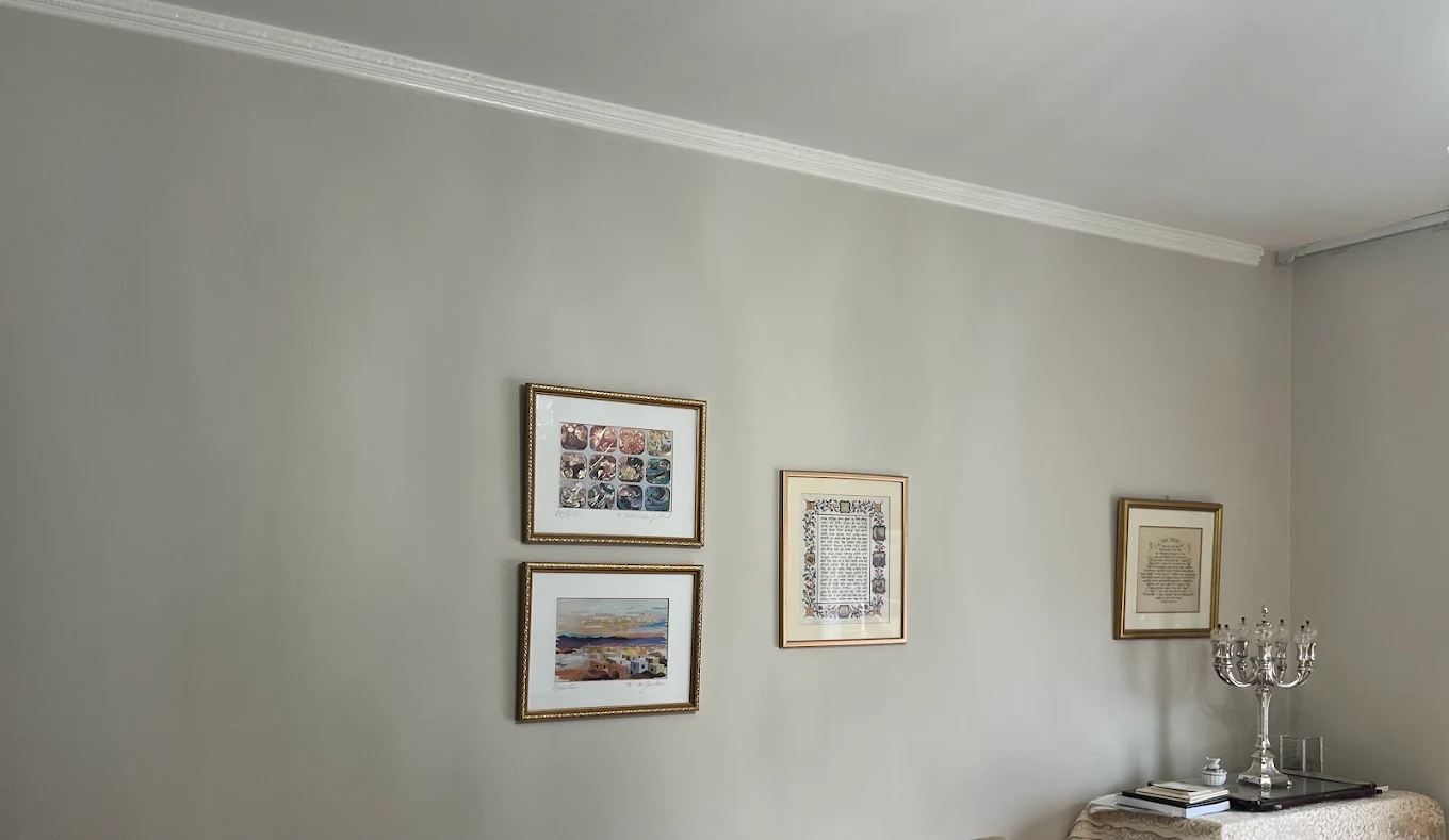Living room walls painted warm greige with crisp white crown molding
